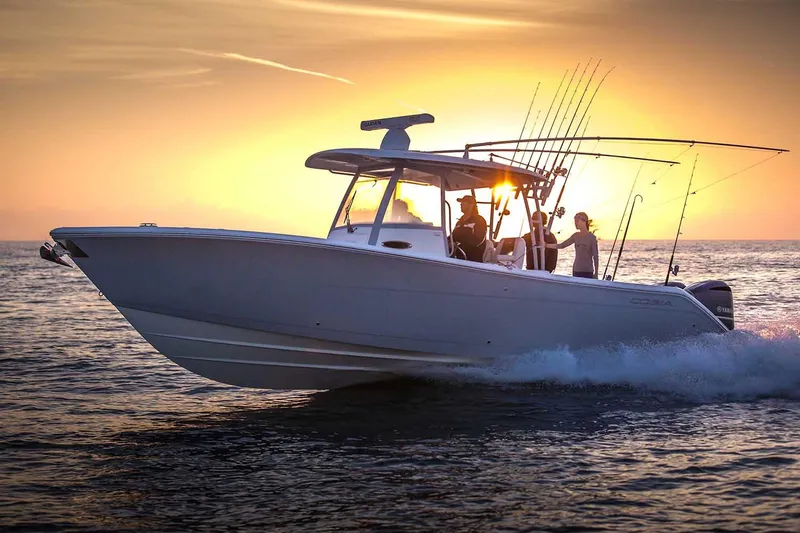 Slide: The Image of Manufacturer Provided Image: 2025 Cobia 320 Center Console boat cruising at sunset with fishing rods. - 4