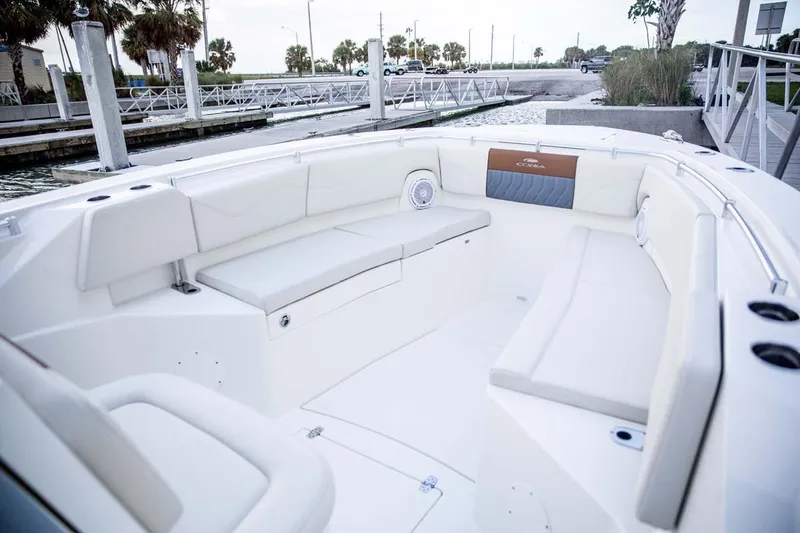 Slide: The Image of Manufacturer Provided Image: 2025 Cobia 320 Center Console boat interior with white seating and waterfront view. - 9