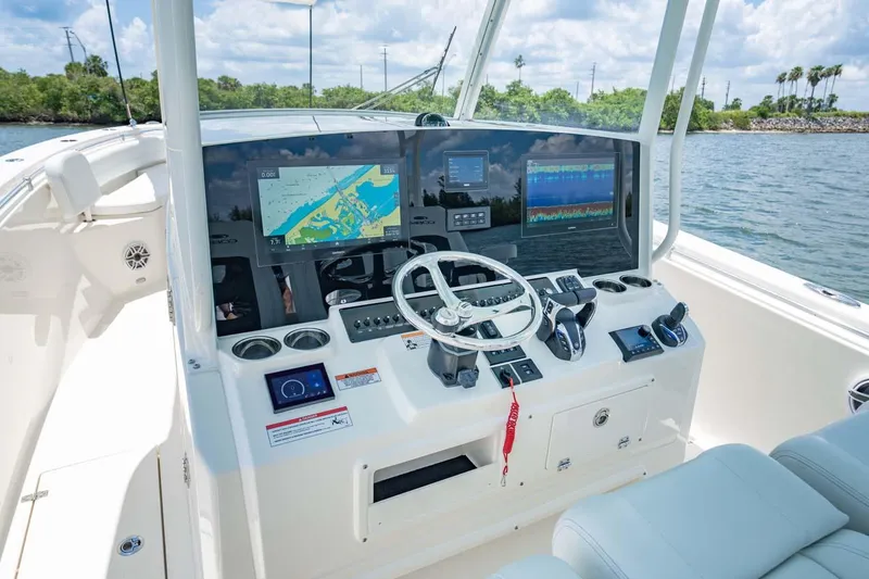 Slide: The Image of Manufacturer Provided Image: 2025 Cobia 350 Center Console boat dashboard with navigation screens and steering wheel. - 11