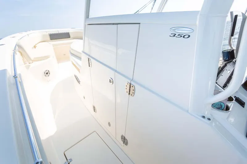 Slide: The Image of Manufacturer Provided Image: 2025 Cobia 350 Center Console boat interior, featuring sleek white cabinetry and seating. - 20
