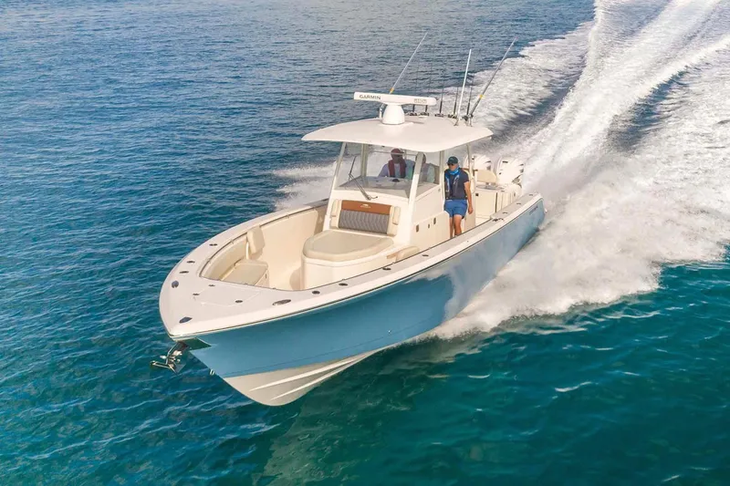 Slide: The Image of Manufacturer Provided Image: 2025 Cobia 350 Center Console boat cruising on clear blue water. - 3