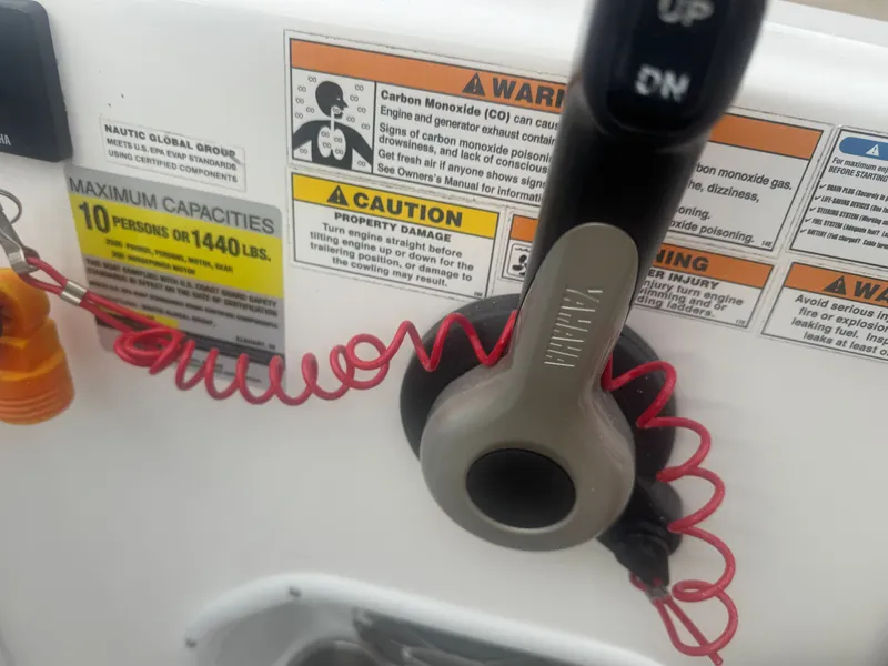 Slide: The Image of Close-up of control lever with warning labels on a 2013 Hurricane SS203-OB boat. - 24