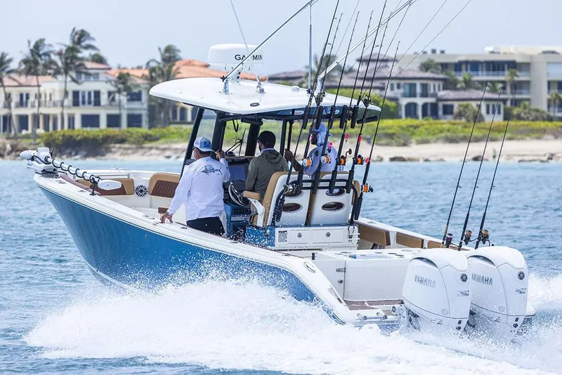 Slide: The Image of Manufacturer Provided Image: 2025 Cobia 265 Center Console Open boat cruising on water with fishing rods. - 11