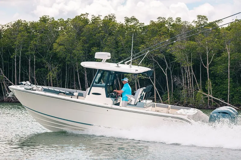 The Image of Manufacturer Provided Image: 2025 Cobia 285 Open Center Console boat cruising on water near mangroves. - 0