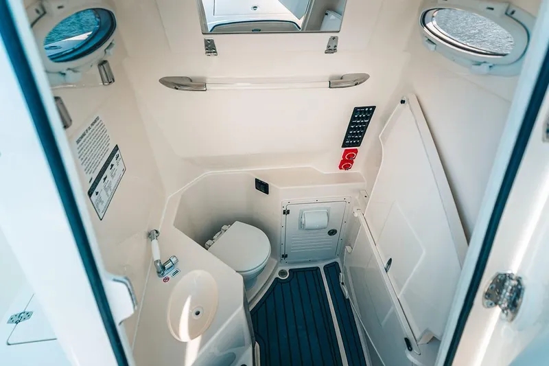 Slide: The Image of Manufacturer Provided Image: 2025 Cobia 285 Open Center Console boat interior with compact bathroom amenities. - 11