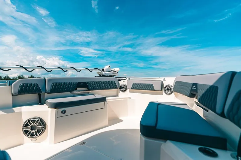 Slide: The Image of Manufacturer Provided Image: 2025 Cobia 285 Open Center Console boat interior with cushioned seating under a clear blue sky. - 2