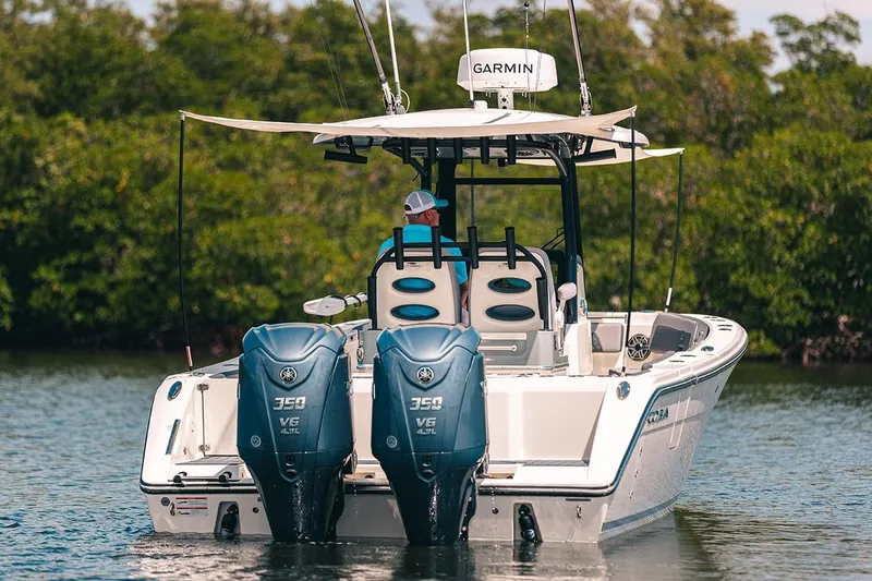 Slide: The Image of Manufacturer Provided Image: 2025 Cobia 285 Open Center Console boat with twin engines on a calm waterway. - 8