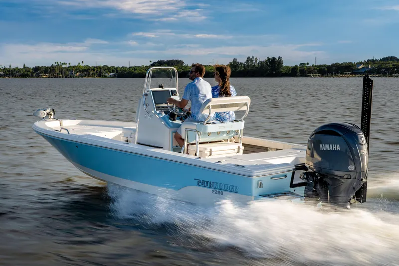 Slide: The Image of Manufacturer Provided Image: 2026 Pathfinder 2200 TRS boat cruising on a calm lake with two passengers. - 1