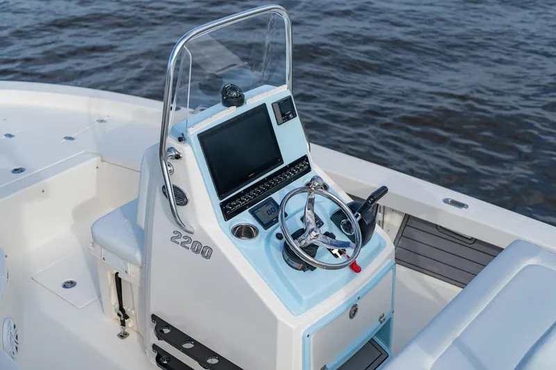 Slide: The Image of Manufacturer Provided Image: 2026 Pathfinder 2200 TRS boat console with steering wheel and navigation screen on water. - 14