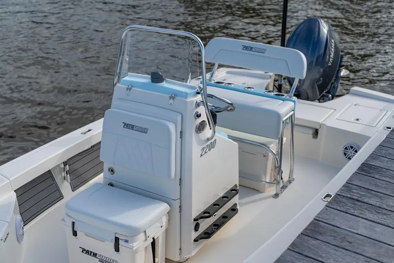 Slide: The Image of Manufacturer Provided Image: 2026 Pathfinder 2200 TRS boat interior with seating and console, docked by the water. - 16