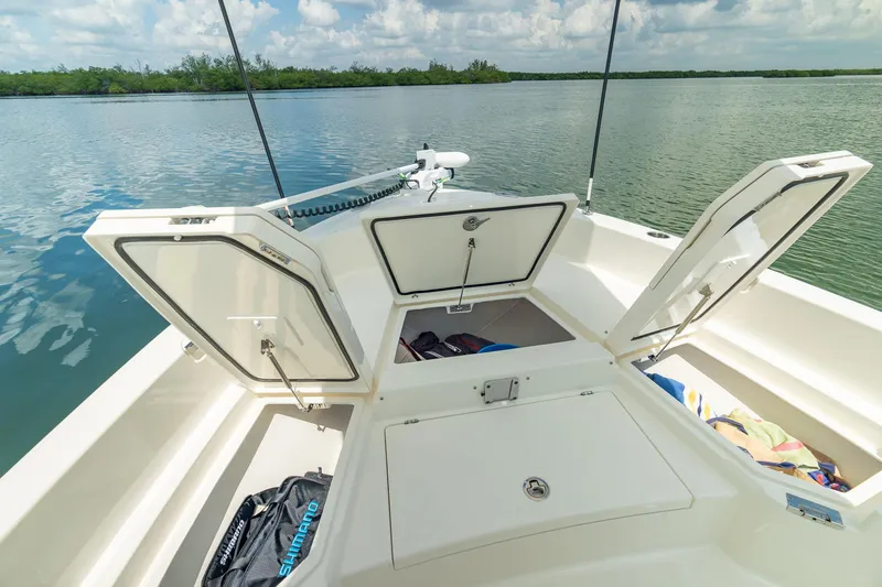 Slide: The Image of Manufacturer Provided Image: 2026 Pathfinder 2400 TRS boat with open storage compartments on a calm lake. - 7