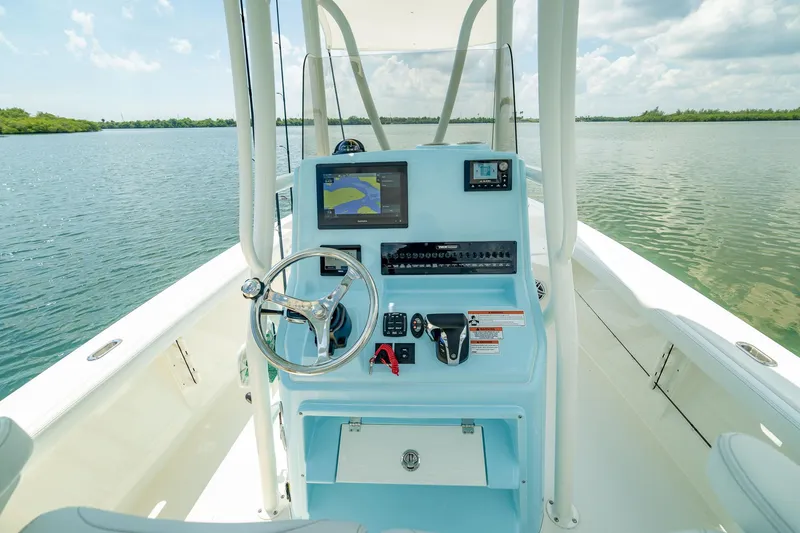 Slide: The Image of Manufacturer Provided Image: 2026 Pathfinder 2400 TRS boat console with navigation screens on a calm lake. - 8
