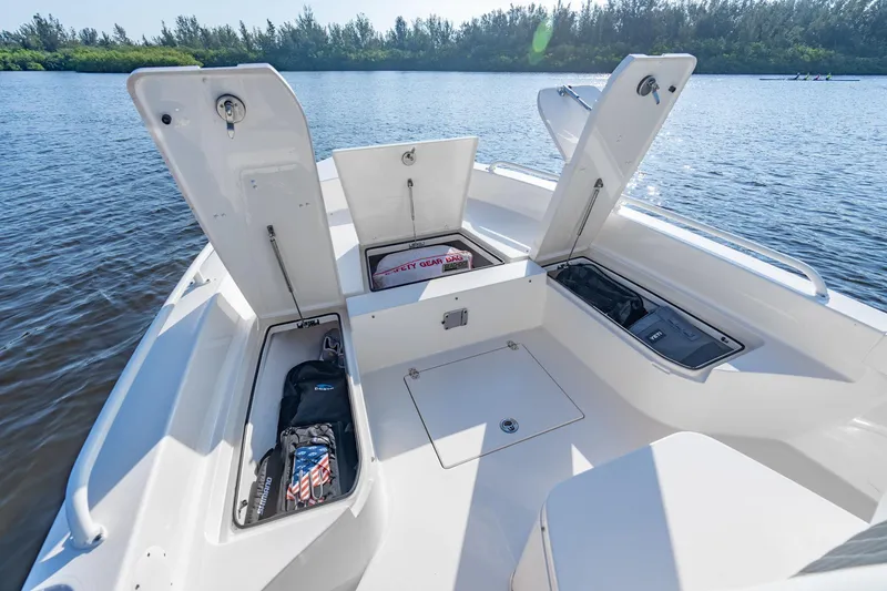 Slide: The Image of Manufacturer Provided Image: 2026 Pathfinder 2600 TRS boat with open storage compartments on a serene lake. - 5