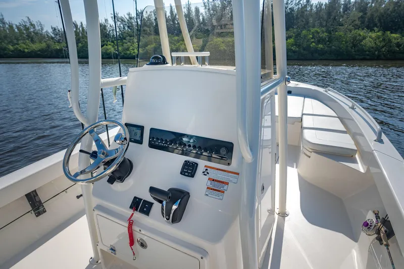 Slide: The Image of Manufacturer Provided Image: 2026 Pathfinder 2600 TRS boat console with steering wheel and controls on a sunny day. - 9