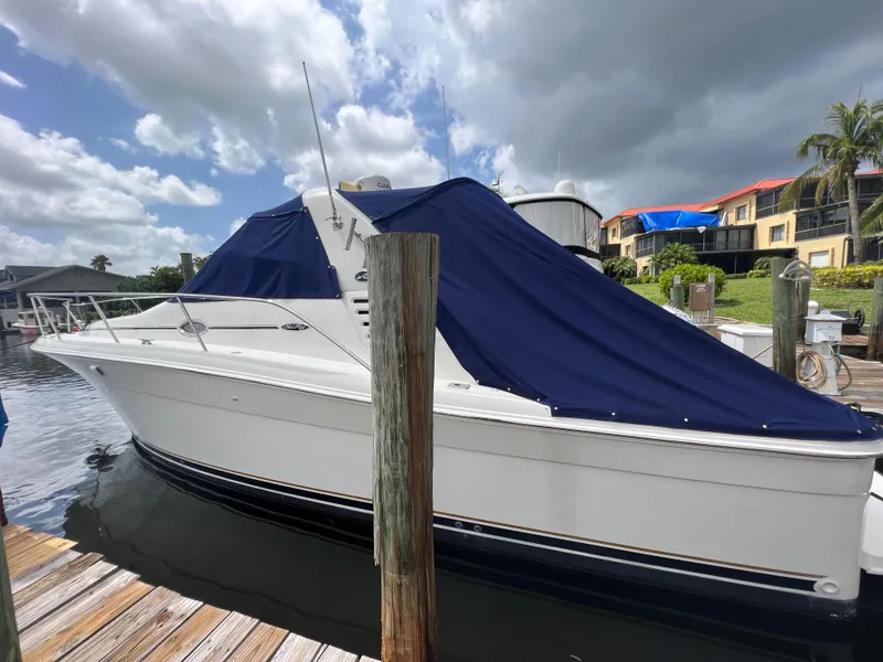Slide: The Image of 2001 Sea Ray 340 Amberjack with blue cover docked at marina. - 3