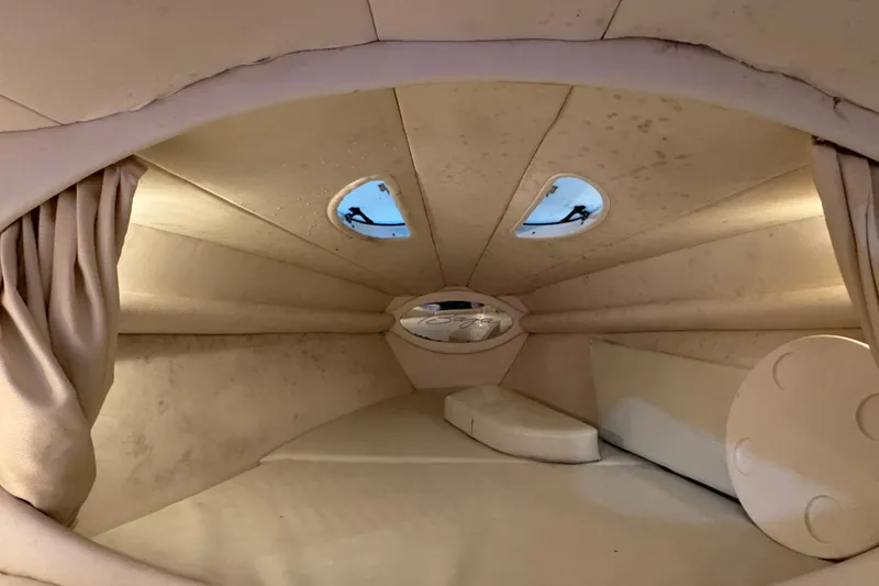 Slide: The Image of Interior cabin of a 2002 Baja .38 Special boat, featuring beige upholstery and portholes. - 23