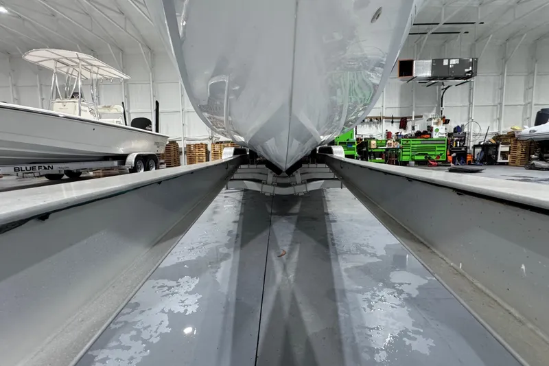 Slide: The Image of 2002 Baja .38 Special boat in a garage, viewed from below, with tools and equipment nearby. - 28