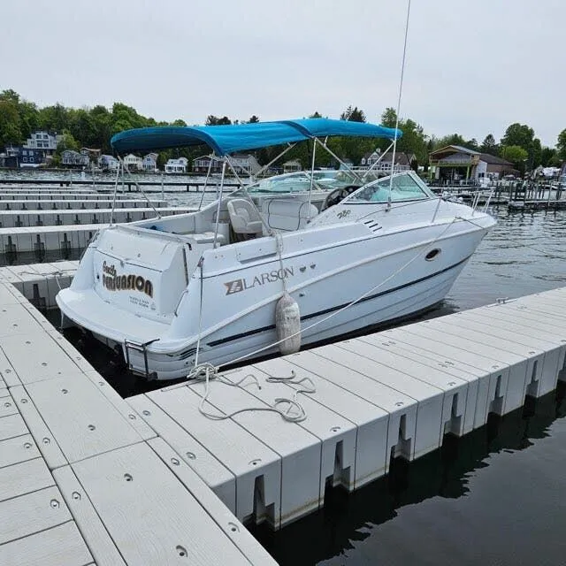 Slide: The Image of 1996 Larson Cabrio 280 boat docked with blue canopy. - 3