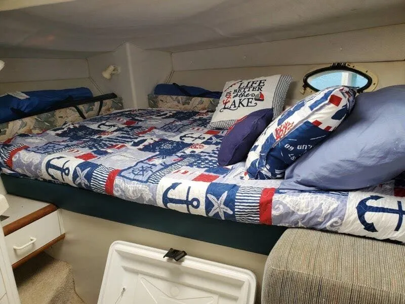 Slide: The Image of Interior of a 1996 Larson Cabrio 280 with nautical-themed bedding. - 8