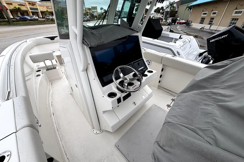 Slide: The Image of 2024 Sailfish 272 CC boat interior with steering console and seating area. - 2