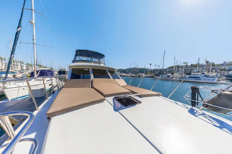 Slide: The Image of 1996 Navigator 5300 Classic yacht docked in a sunny marina, featuring spacious deck and seating. - 17