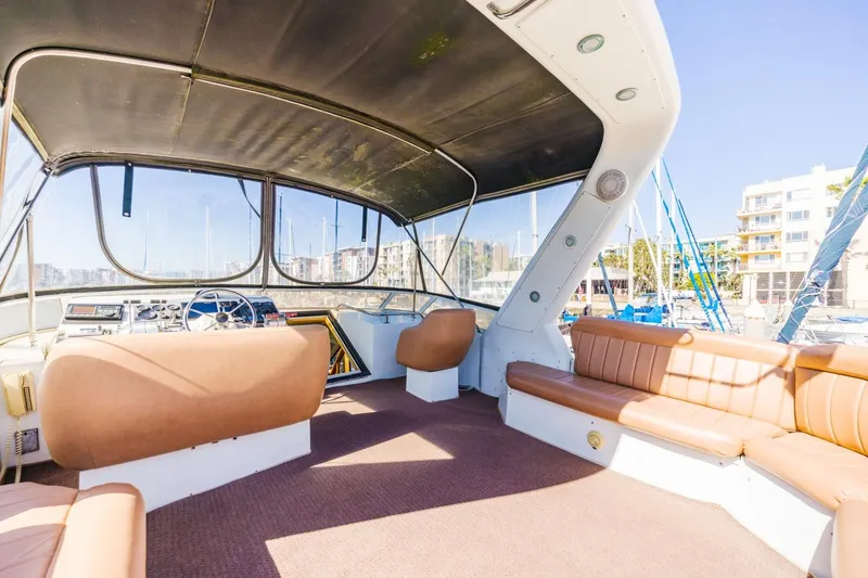 Slide: The Image of 1996 Navigator 5300 Classic yacht interior with brown seating and helm, docked at marina. - 22