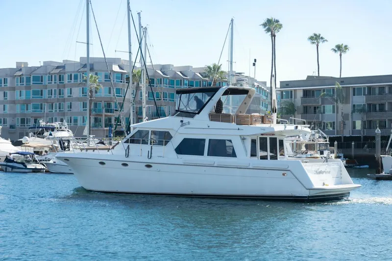 Slide: The Image of 1996 Navigator 5300 Classic yacht docked in marina, surrounded by modern buildings and palm trees. - 3