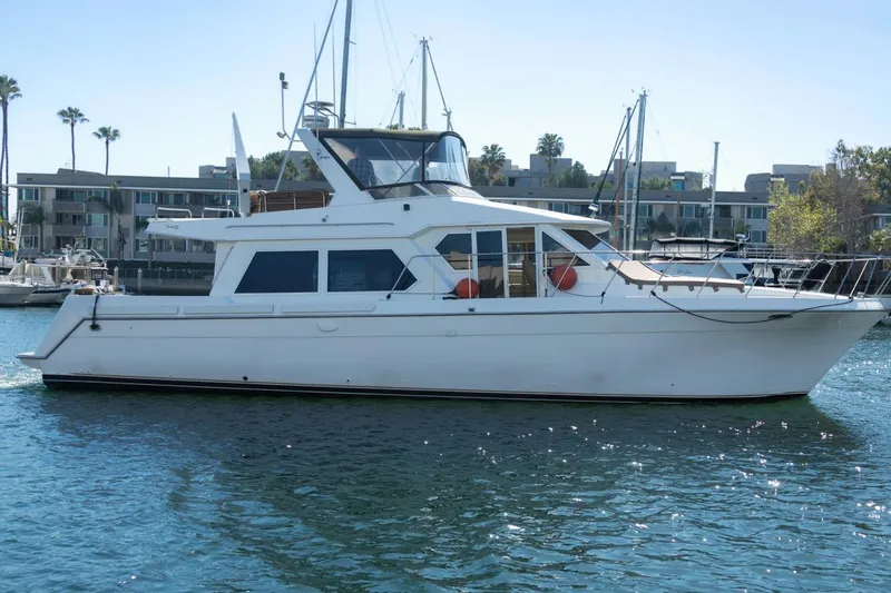 Slide: The Image of 1996 Navigator 5300 Classic yacht docked in marina, clear sky, calm water. - 5