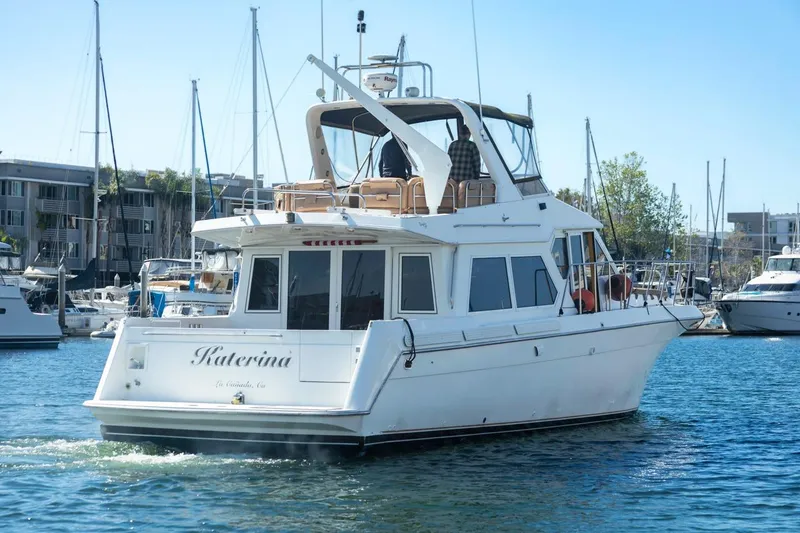 Slide: The Image of 1996 Navigator 5300 Classic yacht in marina, surrounded by other boats and buildings. - 7