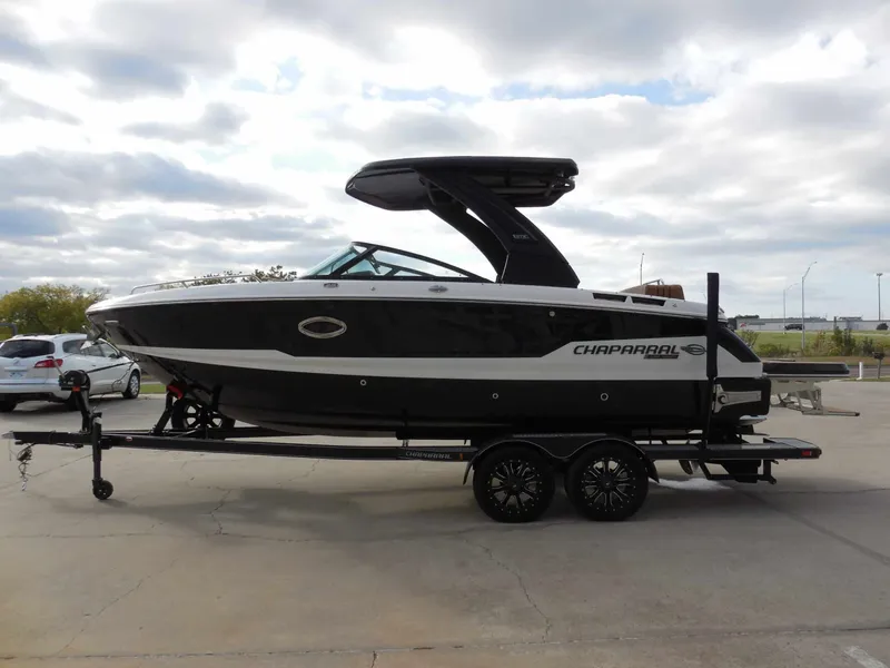 Slide: The Image of A black Chaparral GTS 6 boat from 2026 on a trailer, parked on a concrete lot. - 7