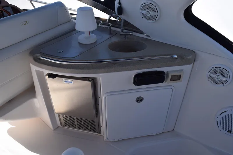 Slide: The Image of 2004 Regal Commodore 3860 yacht kitchenette with sink, mini-fridge, and speakers. - 17
