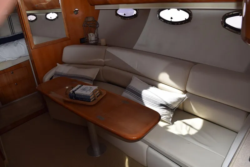 Slide: The Image of 2004 Regal Commodore 3860 yacht interior with beige seating and wooden table. - 22