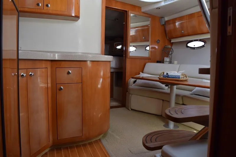 Slide: The Image of 2004 Regal Commodore 3860 yacht interior with wooden cabinetry and cozy seating area. - 24