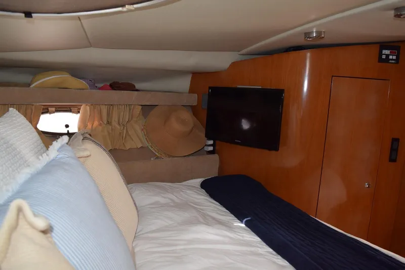 Slide: The Image of Interior cabin of 2004 Regal Commodore 3860 yacht with bed, TV, and storage. - 26