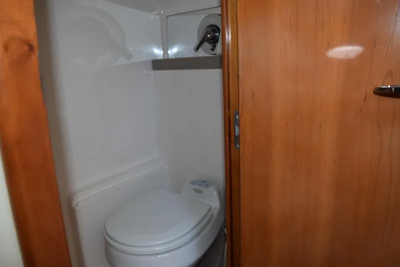 Slide: The Image of Bathroom interior of 2004 Regal Commodore 3860 yacht, featuring a compact toilet. - 28