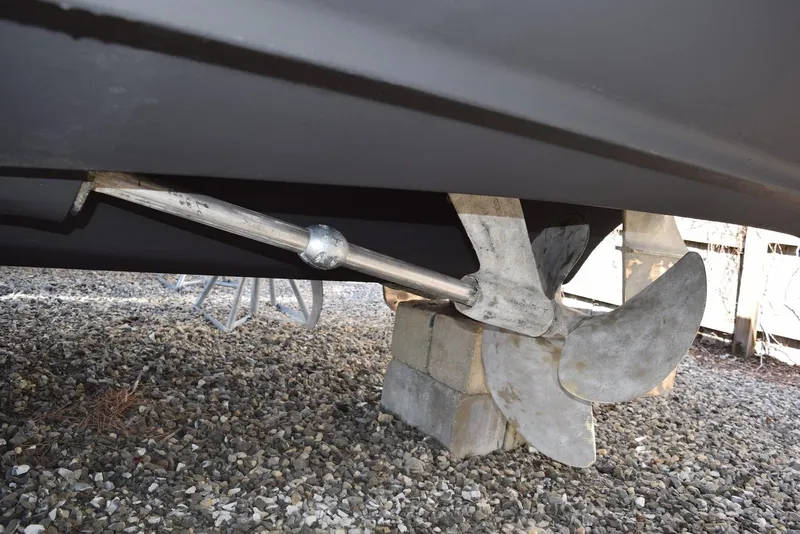 Slide: The Image of 2004 Regal Commodore 3860 boat propeller and shaft on gravel. - 33