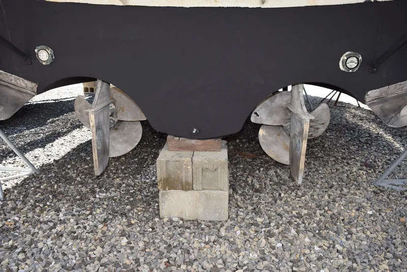 Slide: The Image of 2004 Regal Commodore 3860 boat propellers on gravel, supported by concrete blocks. - 34