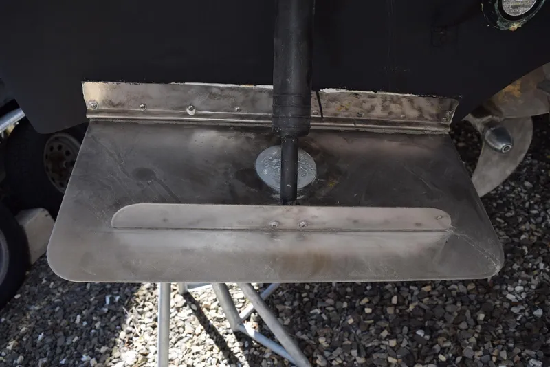 Slide: The Image of Trim tab of a 2004 Regal Commodore 3860 boat on gravel surface. - 35