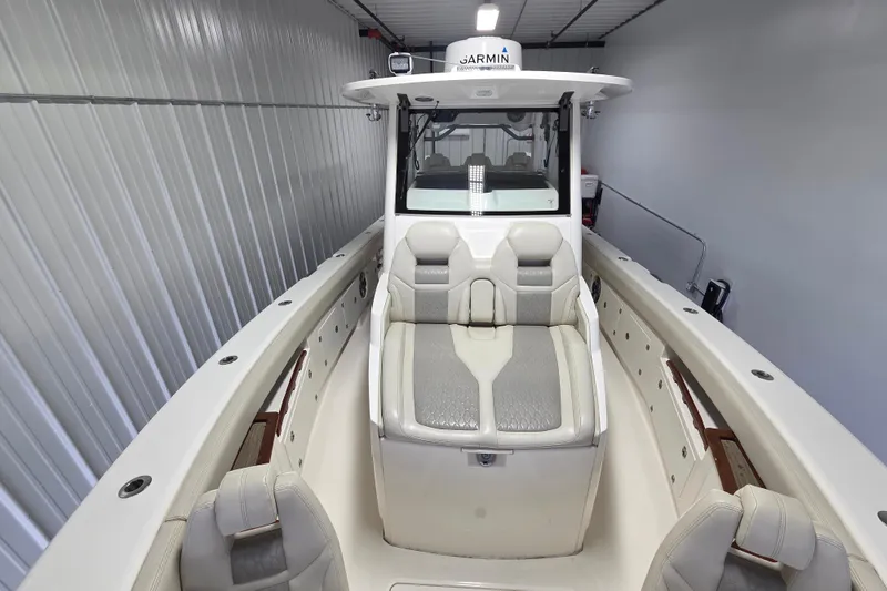 Slide: The Image of 2020 Solace 345 boat interior with cushioned seating and Garmin equipment in a storage facility. - 7
