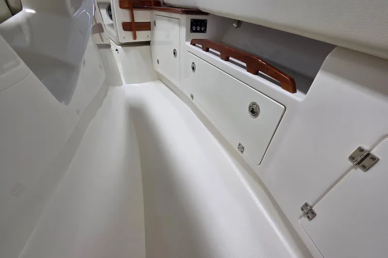 Slide: The Image of Interior view of 2020 Solace 345 boat, featuring sleek white design and storage compartments. - 24
