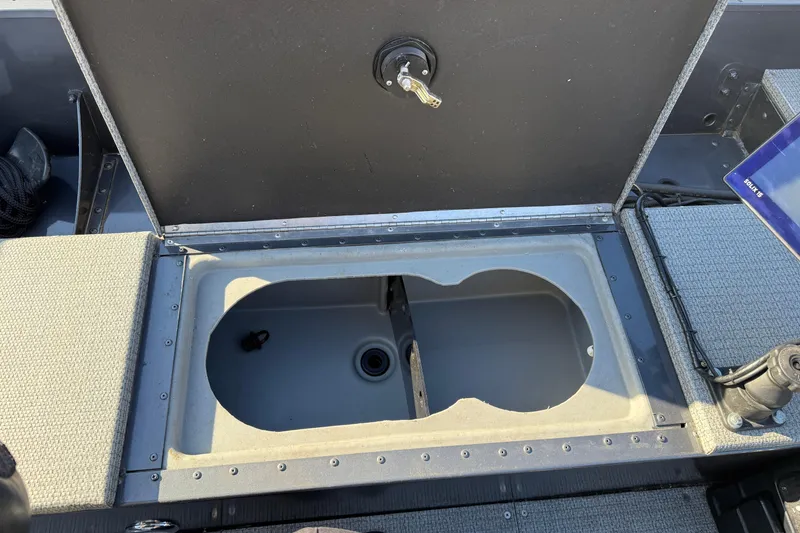 Slide: The Image of Open storage compartment in 2022 G3 Angler V17 T boat, featuring carpeted interior. - 24