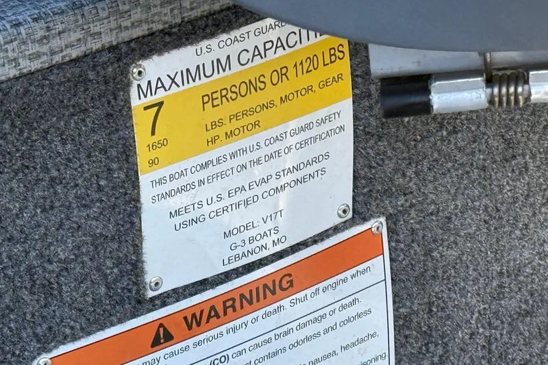 Slide: The Image of 2022 G3 Angler V17 T capacity label, maximum 7 persons or 1120 lbs, safety compliance. - 28