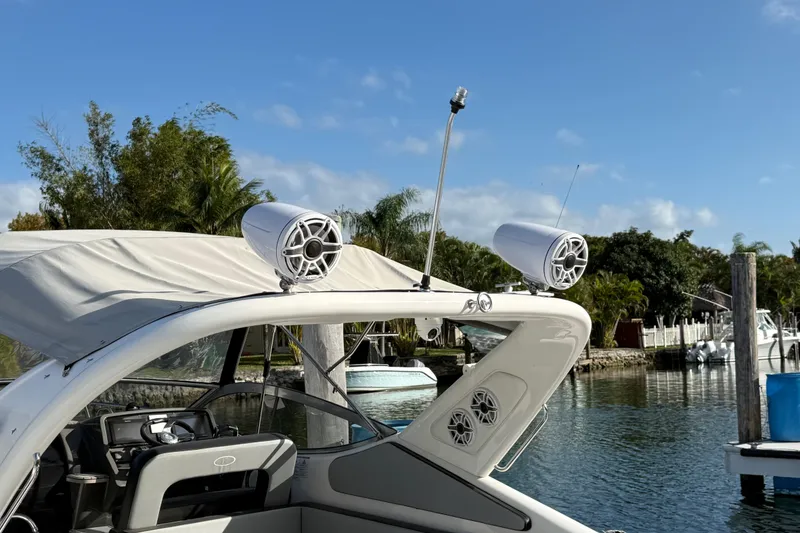 Slide: The Image of Schaefer 303 boat, 2021 model, with speakers and canopy, docked by a serene waterfront. - 10