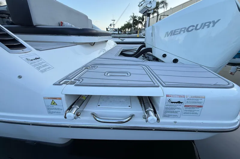 Slide: The Image of Schaefer 303 boat with Mercury engine, 2021 model, featuring swim platform and safety labels. - 11