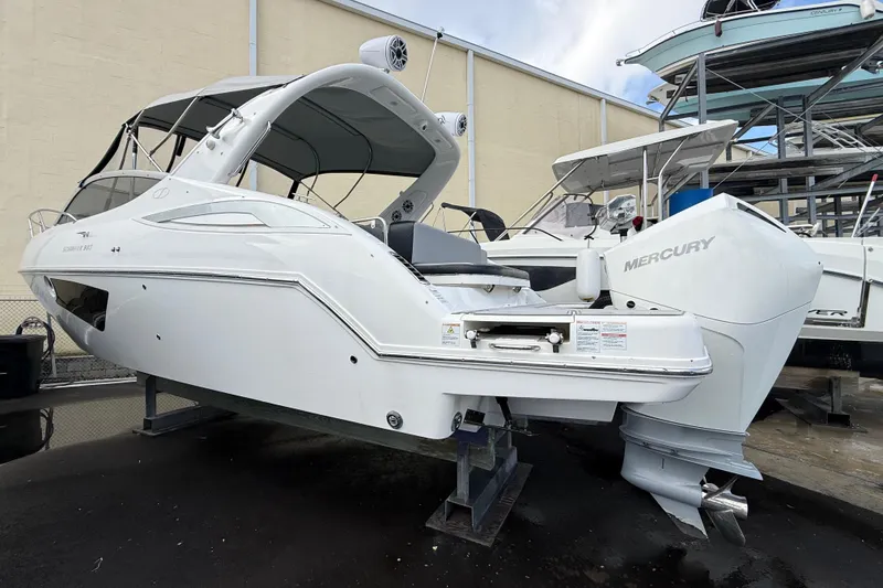 Slide: The Image of 2021 Schaefer 303 boat with Mercury engine, displayed on a stand in a marina. - 32