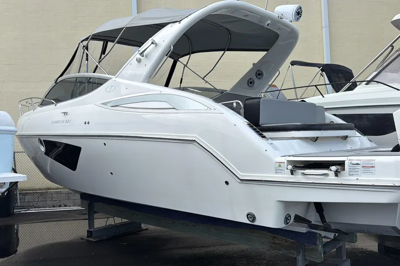 Slide: The Image of 2021 Schaefer 303 boat with sleek design and canopy, displayed on a stand. - 33