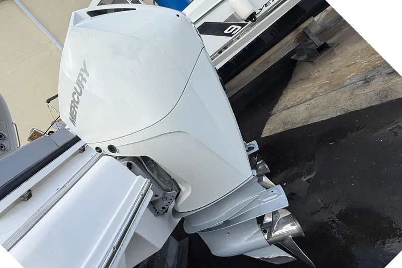 Slide: The Image of Schaefer 303 boat with Mercury outboard motor, 2021 model, docked on wet pavement. - 35