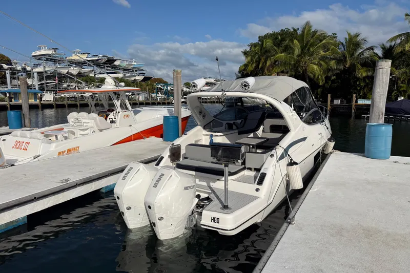 Slide: The Image of 2021 Schaefer 303 boat docked at marina with palm trees and clear sky. - 4