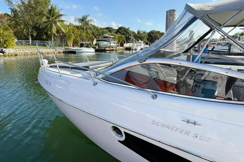 Slide: The Image of 2021 Schaefer 303 boat docked in a scenic marina with palm trees. - 6