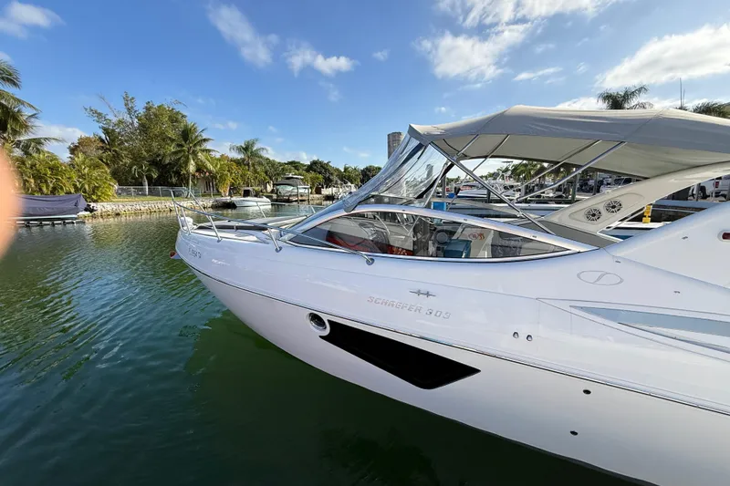 Slide: The Image of 2021 Schaefer 303 boat docked in a scenic marina with palm trees. - 8